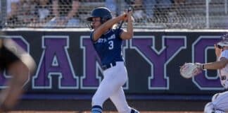 Female softball player in a blue uniform (number 3) swings at a pitch at home plate, catcher nearby behind the plate.