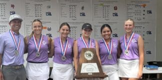 Coach and five young female golfers in purple shirts wearing medals, posing with a large award plaque.