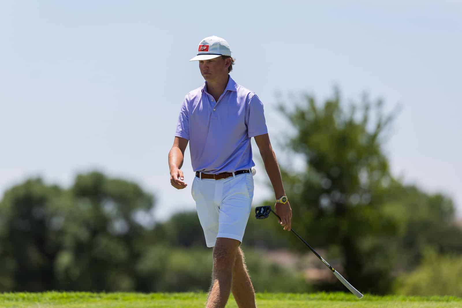 asco-tall-tower-open-amarillo-jpegJoe-74 | Press Pass Sports Golf or mini-photoshoot: a man in a purple polo and white shorts walking on a golf course, holding a club and rangefinder, under sunny skies