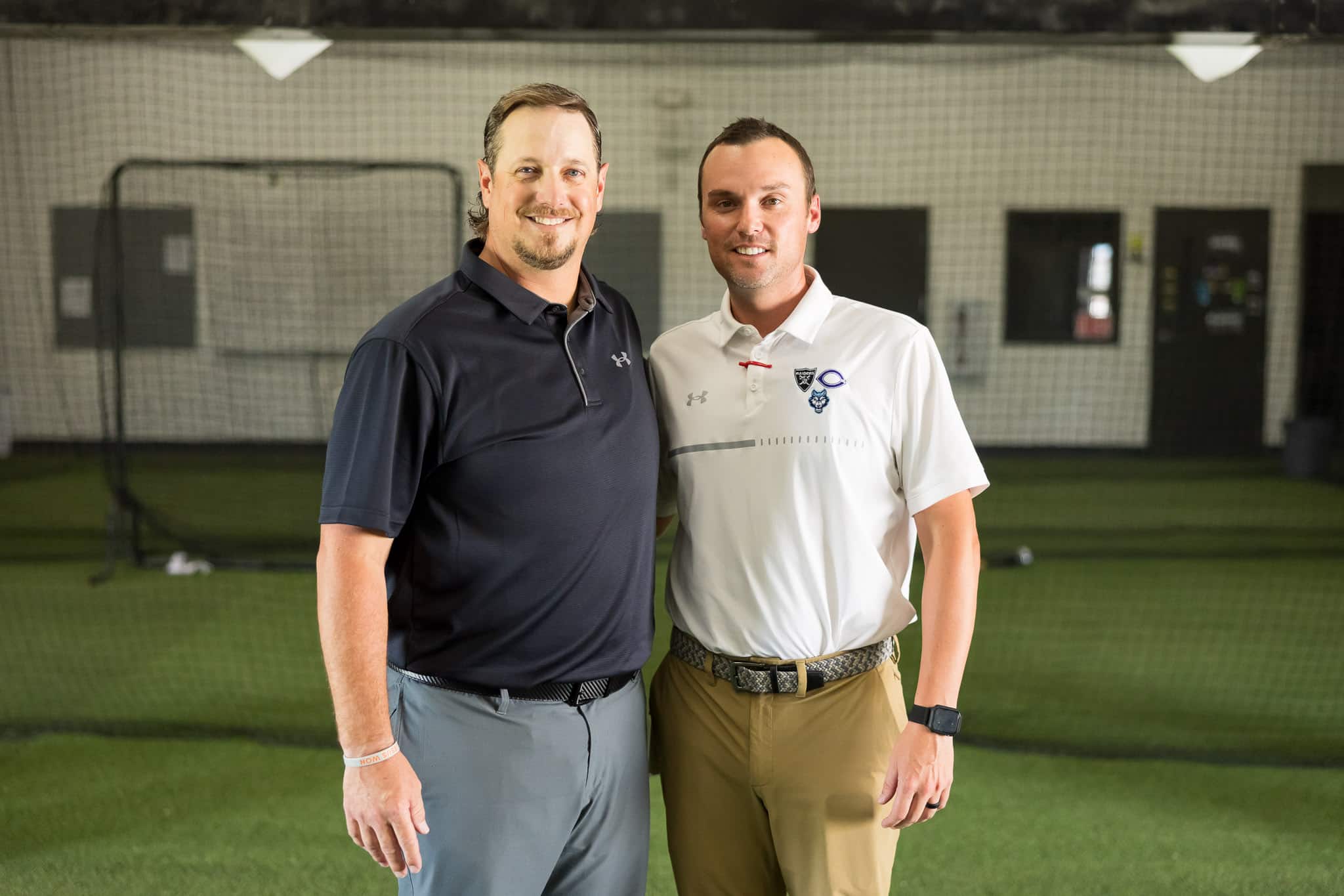 randall-new-baseball-coach-jpegJoe-3 | Press Pass Sports Two men posing for a photo in an indoor sports facility, smiling at the camera.